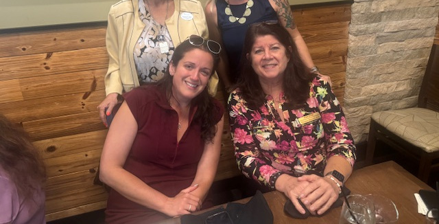 Women smiling at a WINK meeting